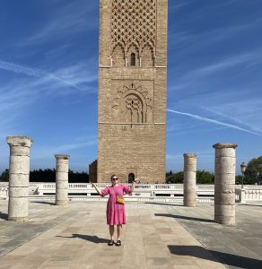 Charlotte standing in front of the Hassan Tower in Morocco