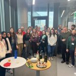 The Musculoskeletal Mechanics research laboratory team gather around two tables full of cake and champagne to celebrate Caitlin's successful thesis defence