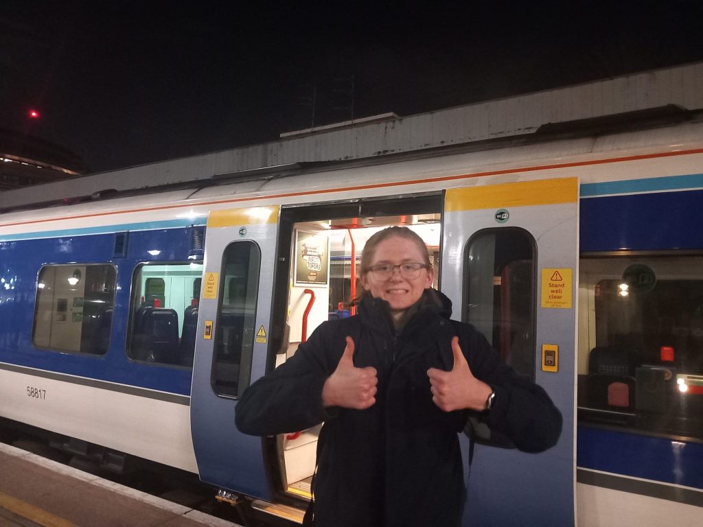 Hamish smiling infront of a parked train with both thumbs up