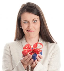 Woman looking disappointed with an unwanted gift