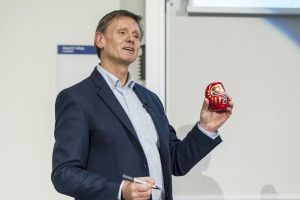 Martyn Kingsbury drawing an eye on a red Japanese Daruma doll