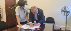Tim Green signing the shirt at his desk