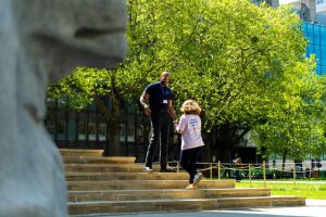 Security guard talking to a person on Queens Tower steps