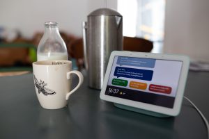 A smart home device next to a mug on a kitchen counter