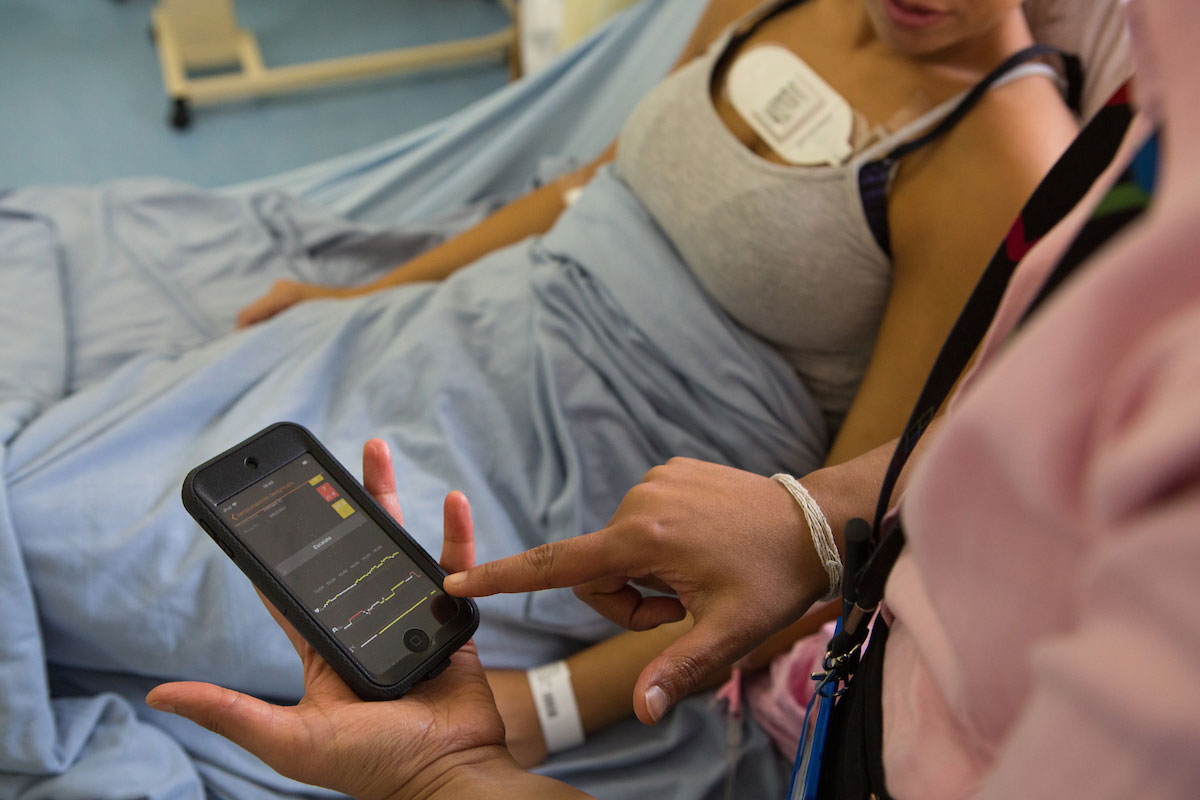 A doctor showing a patient vital signs on a smartphone