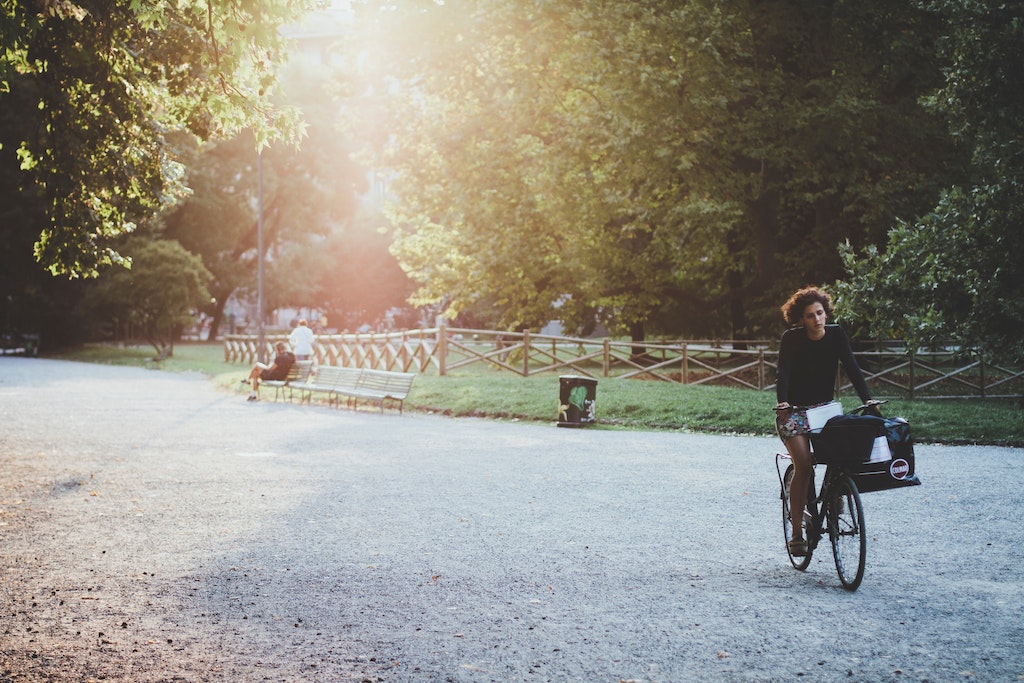 Woman cycling in a park, a healthy environment to some