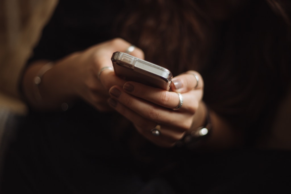 A woman using a mobile phone, demonstrating how text messaging can be used in population screening