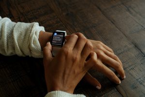 A smart watch on a wrist with a message that says "Well done! You have reached your daily goal"