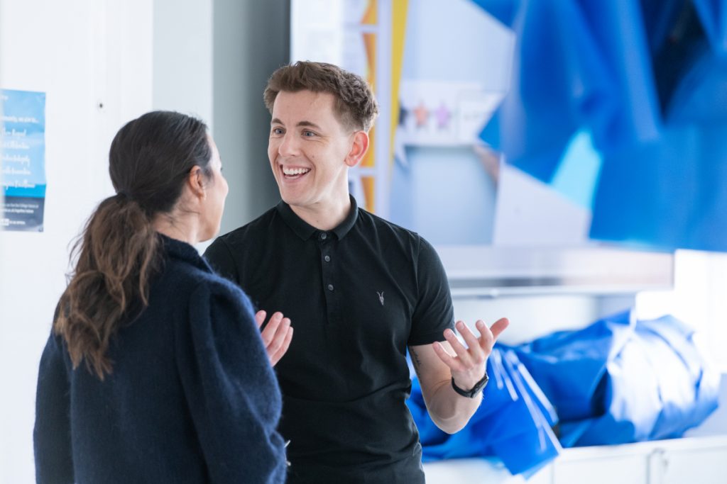 Two people stand and chat