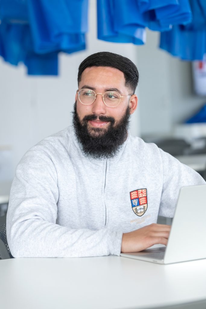 Mizan Musahid sits with laptop