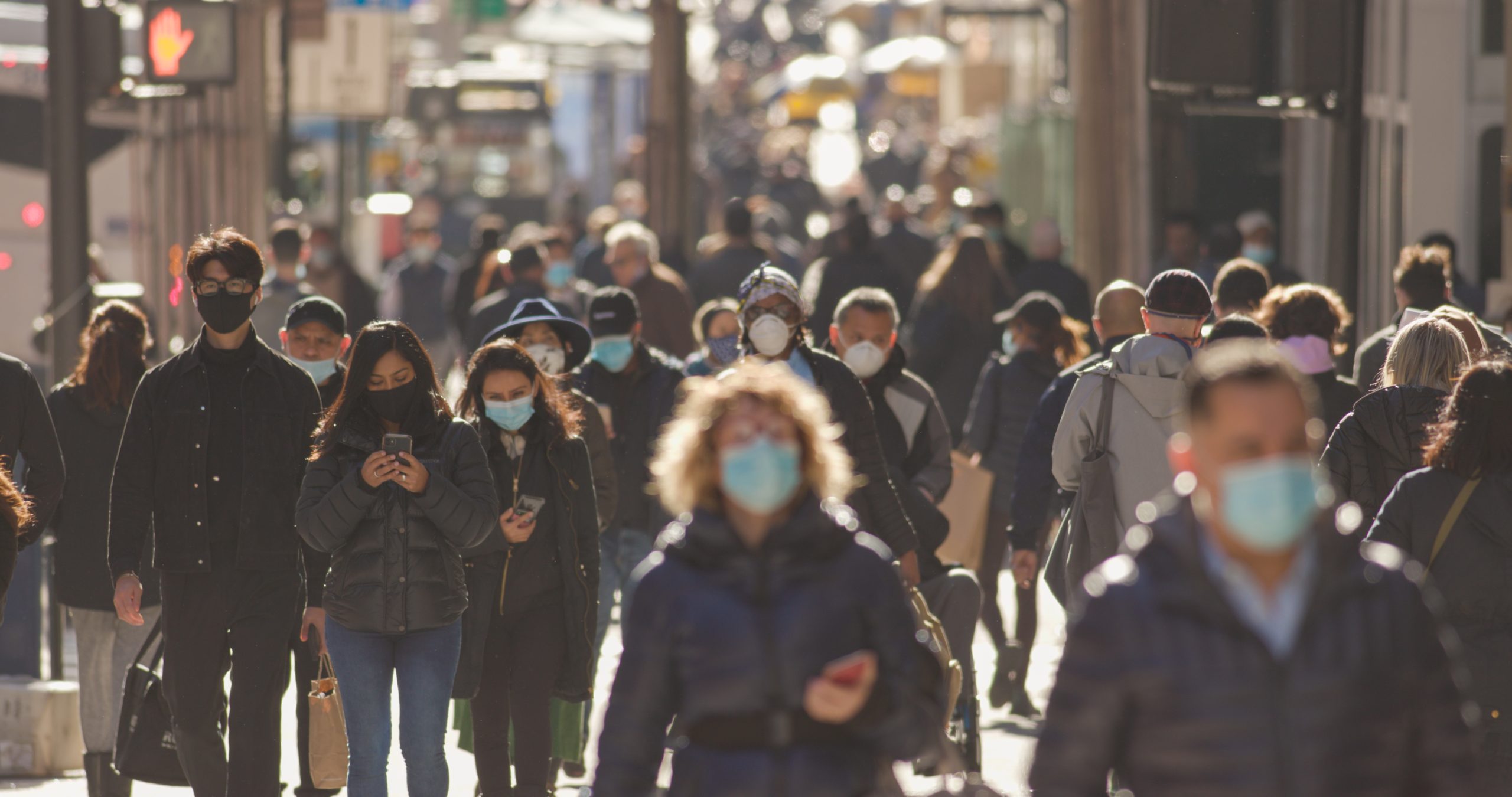 New York circa November 2020: Crowd of people walking on the street wearing masks during COVID-19 pandemic. Credit: blvdone / Shutterstock.com.