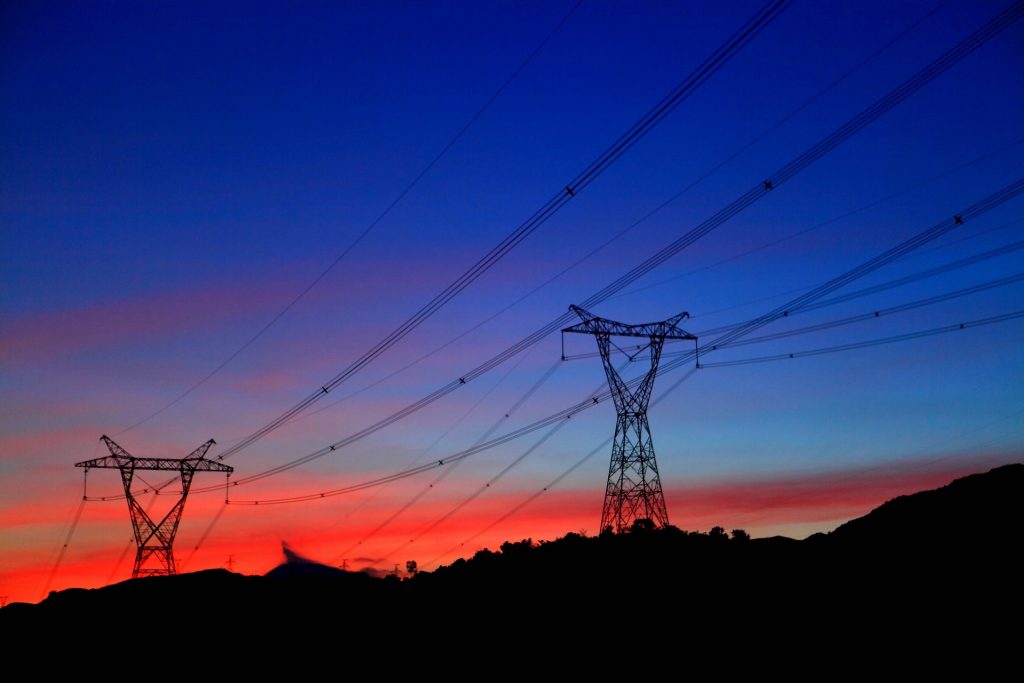 Electricity pylons against a sunset.