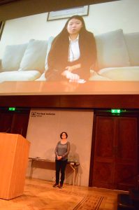 Photo of Professor Sykes with her winner’s (Zerlynde Goik’s) video in the background. Demonstrates the multi-mode delivery of the awards ceremony, since not everyone could make it, so we displayed videos on the big screen sent in by winners. 