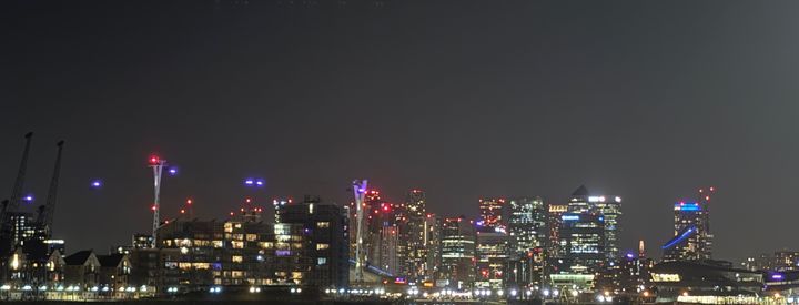 London skyline at night with lots of tall buildings lit up