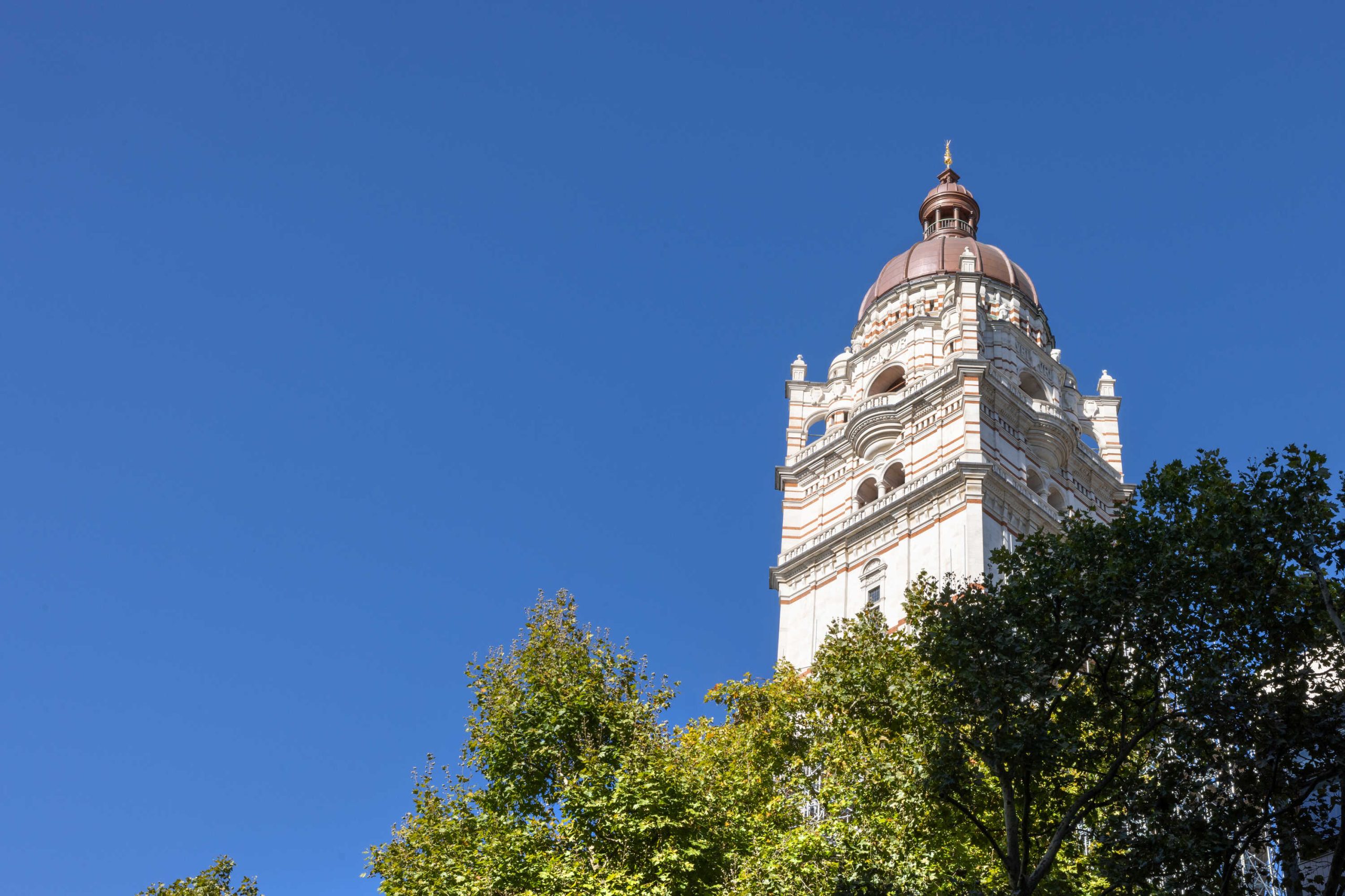Looking up at the Queen's Tower with a blue sky background