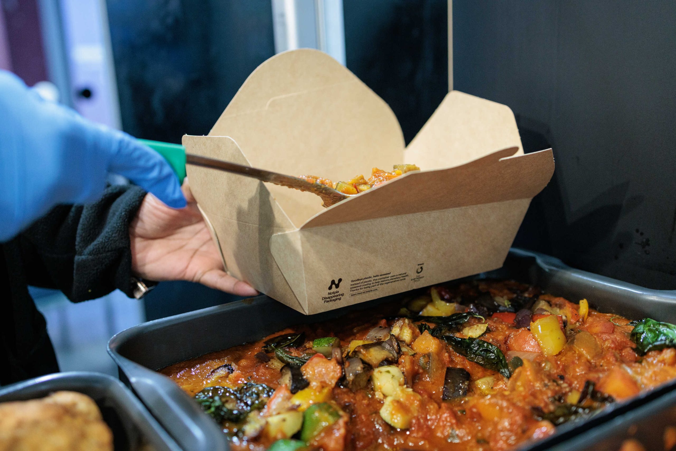 Photo of plant-based meal being served in Notpla packaging.